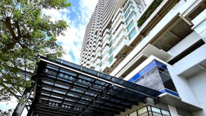 A modern building with a glass facade, a covered entrance, and a clear sky. - Howard Johnson by Wyndham Tangerang (Tangerang)