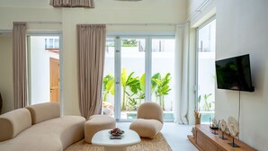 A modern living room with a sofa, armchairs, a coffee table, and a TV. - Lyma Loft (Munggu)
