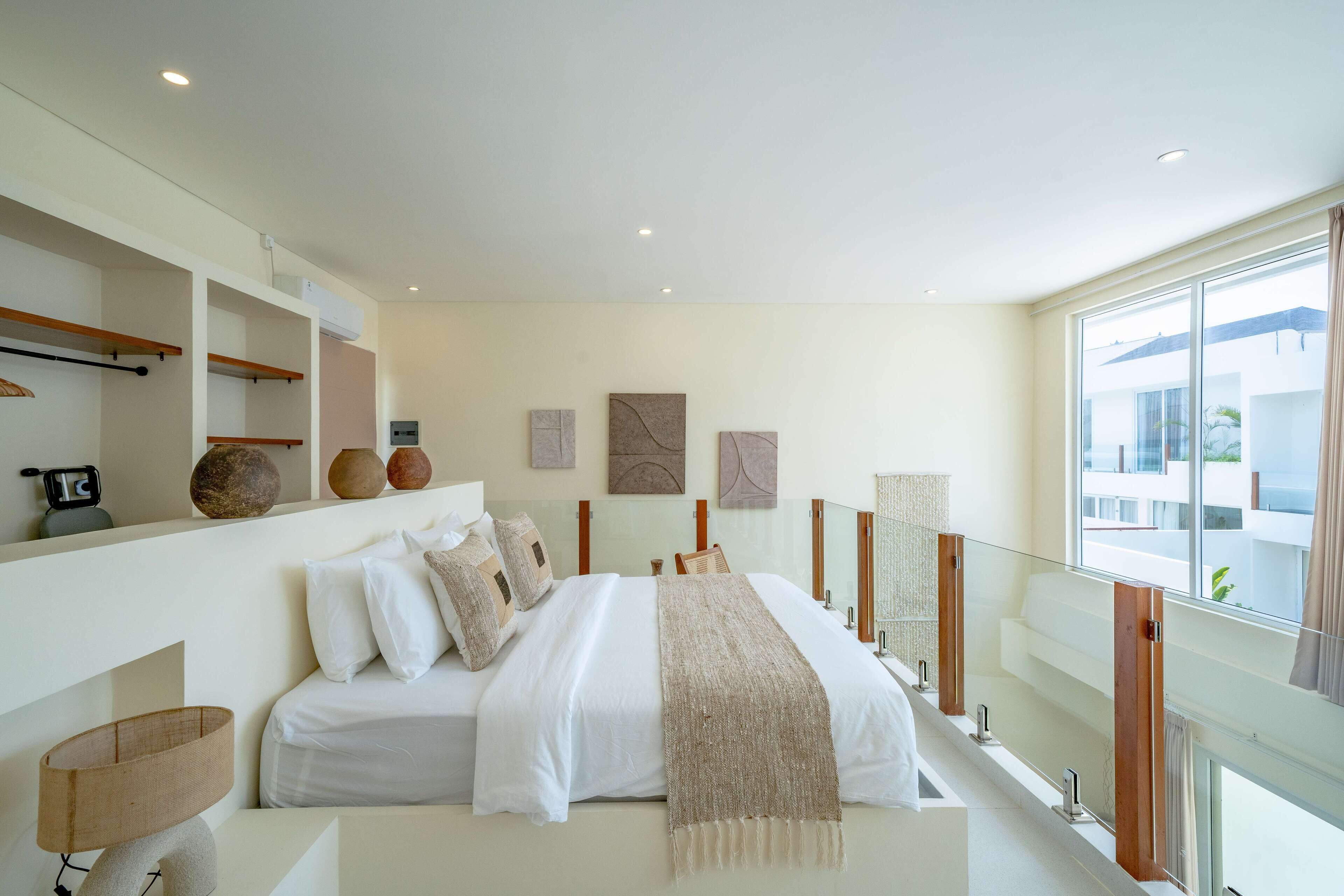 A modern bedroom with a large bed, bedside lamps, and a view of the outside.