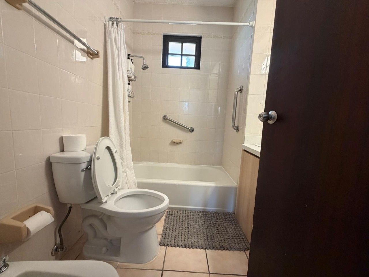A bathroom with a toilet, sink, bathtub, and shower.