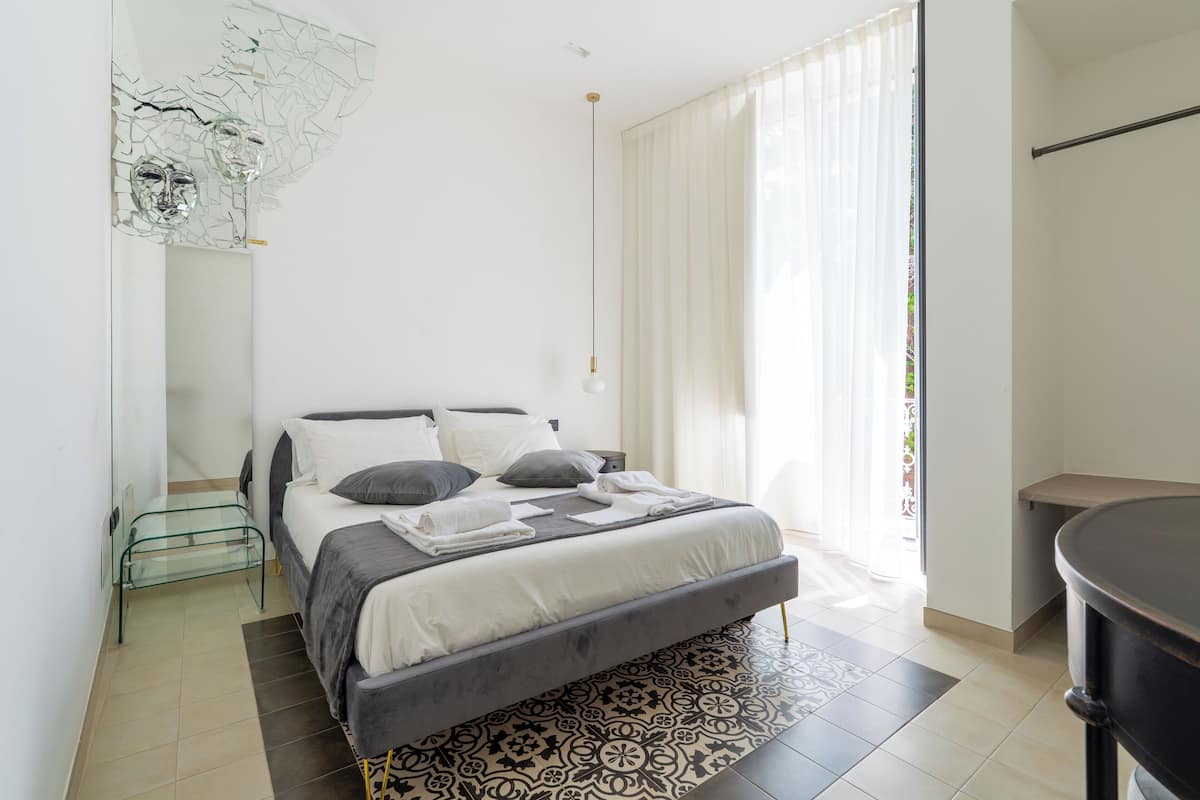 A modern bedroom with a bed, bedside table, and a glass coffee table.