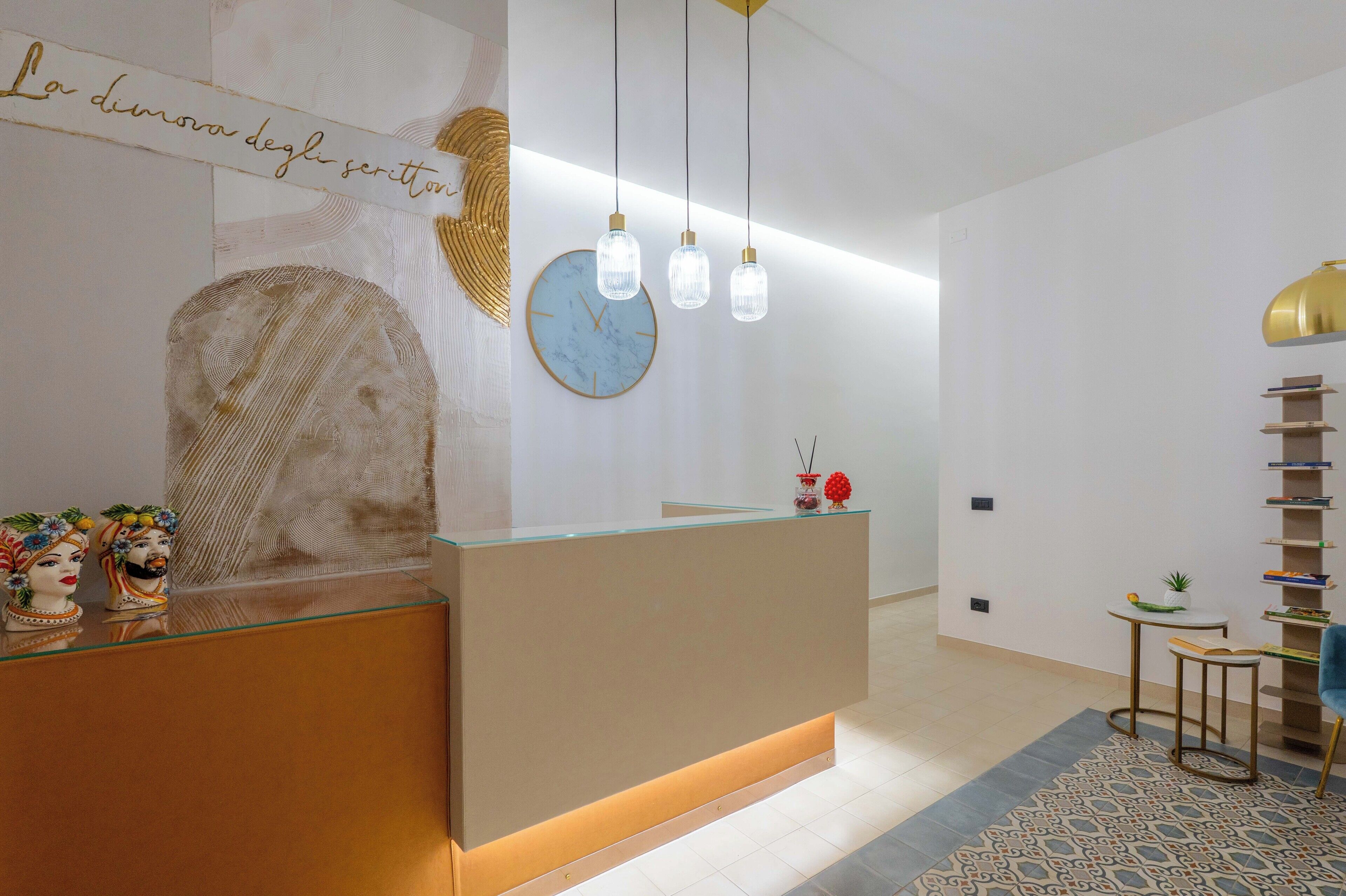 A reception area with a glass counter, a clock, and pendant lights.