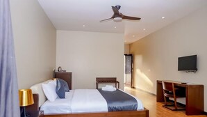 A modern hotel room with a wooden bed, a desk, a ceiling fan, and a flat-screen TV. - Ravissant Hotel Mandrem (Mandrem)