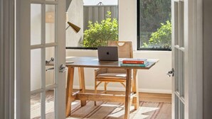 A room with a wooden desk, a laptop, and a book titled 'Explore Australia.'