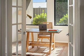A room with a wooden desk, a laptop, and a book titled 'Explore Australia.'