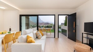 A modern living room with a sofa, chairs, a dining area, and a TV. - Vivelorural Agaete Serenity garden in El Turmán (Agaete)
