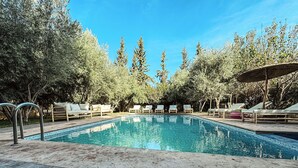 Une piscine avec des chaises longues et une terrasse en bois.