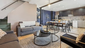 A modern living room with a sofa, coffee table, and dining area. - Suite 332 Brady – Stunning Duplex in Paris 10 (Paris)