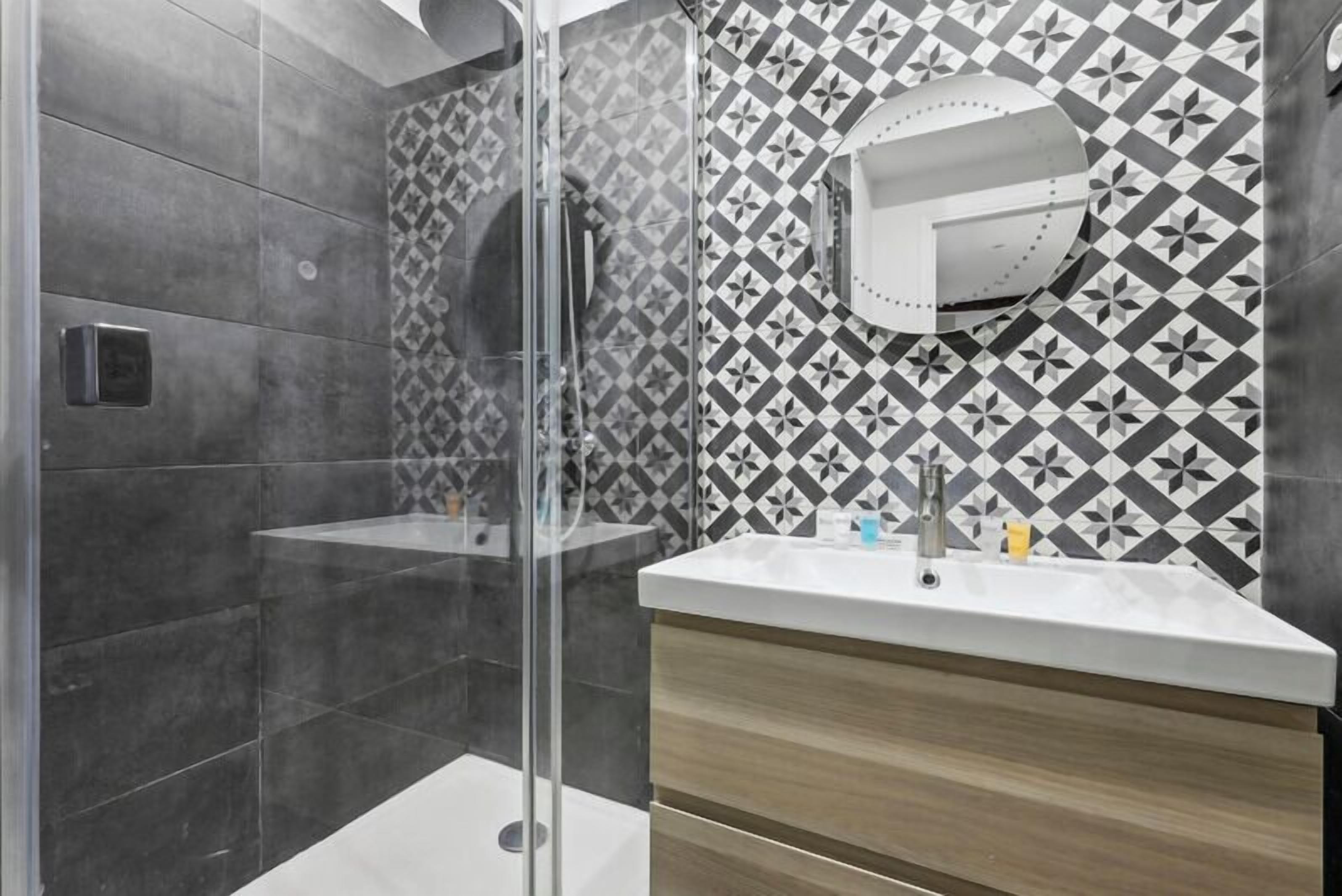 A modern bathroom with a shower, a sink, and a vanity.
