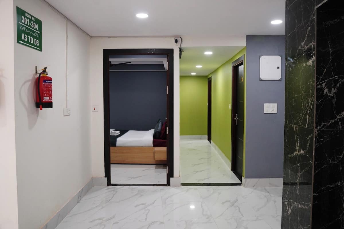 Una habitación de hotel con una cama, un extintor y un cartel con los números de la habitación.