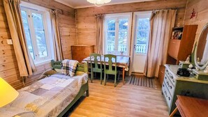 A cozy room with a bed, a desk, a chair, and a dresser.