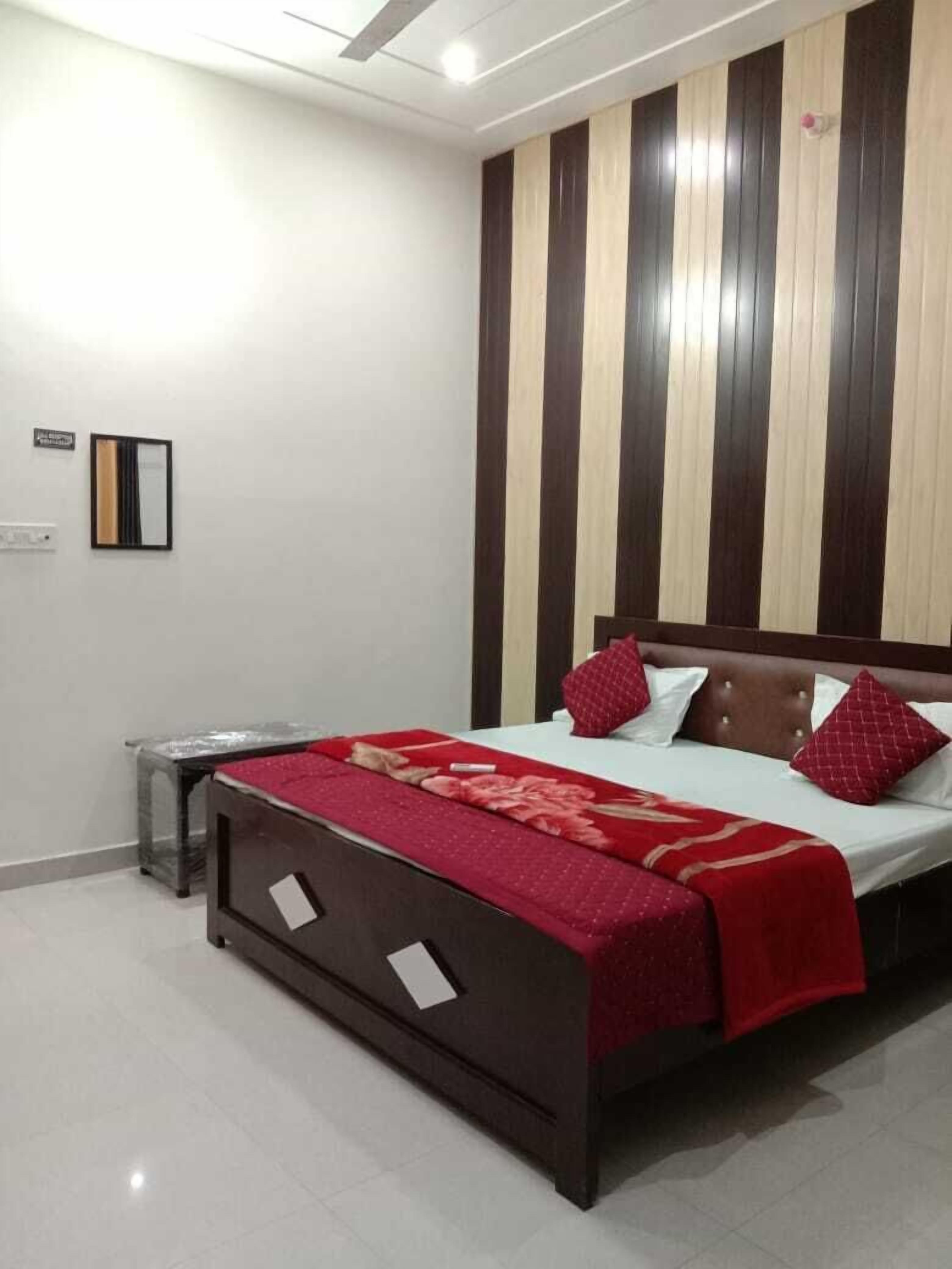 A bedroom with a bed, a nightstand, and a wall-mounted shelf.