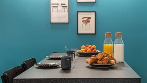 Ein Frühstückstisch mit Croissants, Obst und Saftflaschen.