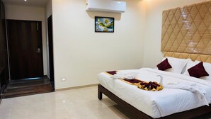 Una habitación de hotel con cama, un cuadro y un equipo de aire acondicionado.