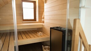 A small, wooden room with a window, a wooden bench, a black trash bin, and a wooden bucket. - Apartment 'Schwarzwald-Wellness byHannes' with Mountain View, Wi-Fi and Air Conditioning (Oberkirch)