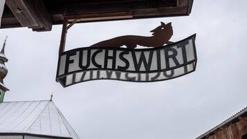 A sign with a wolf silhouette and the word 'FUCHSWIRT' on a building.