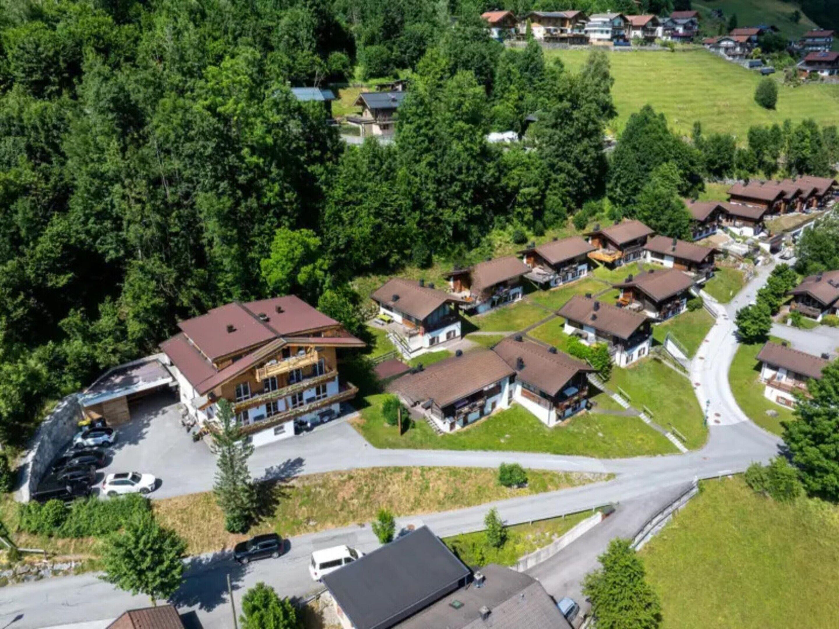 A residential area with multiple houses, a parking lot, and a road.