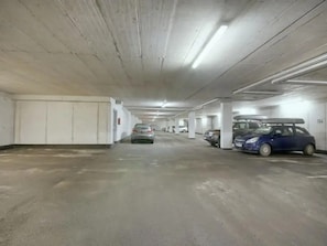 A multi-level underground parking garage with concrete pillars and fluorescent lighting. - Detached Alpine Chalet With Sauna (Wald im Pinzgau)