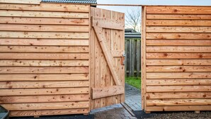 Una puerta de madera que da a un edificio con tejado de tejas.