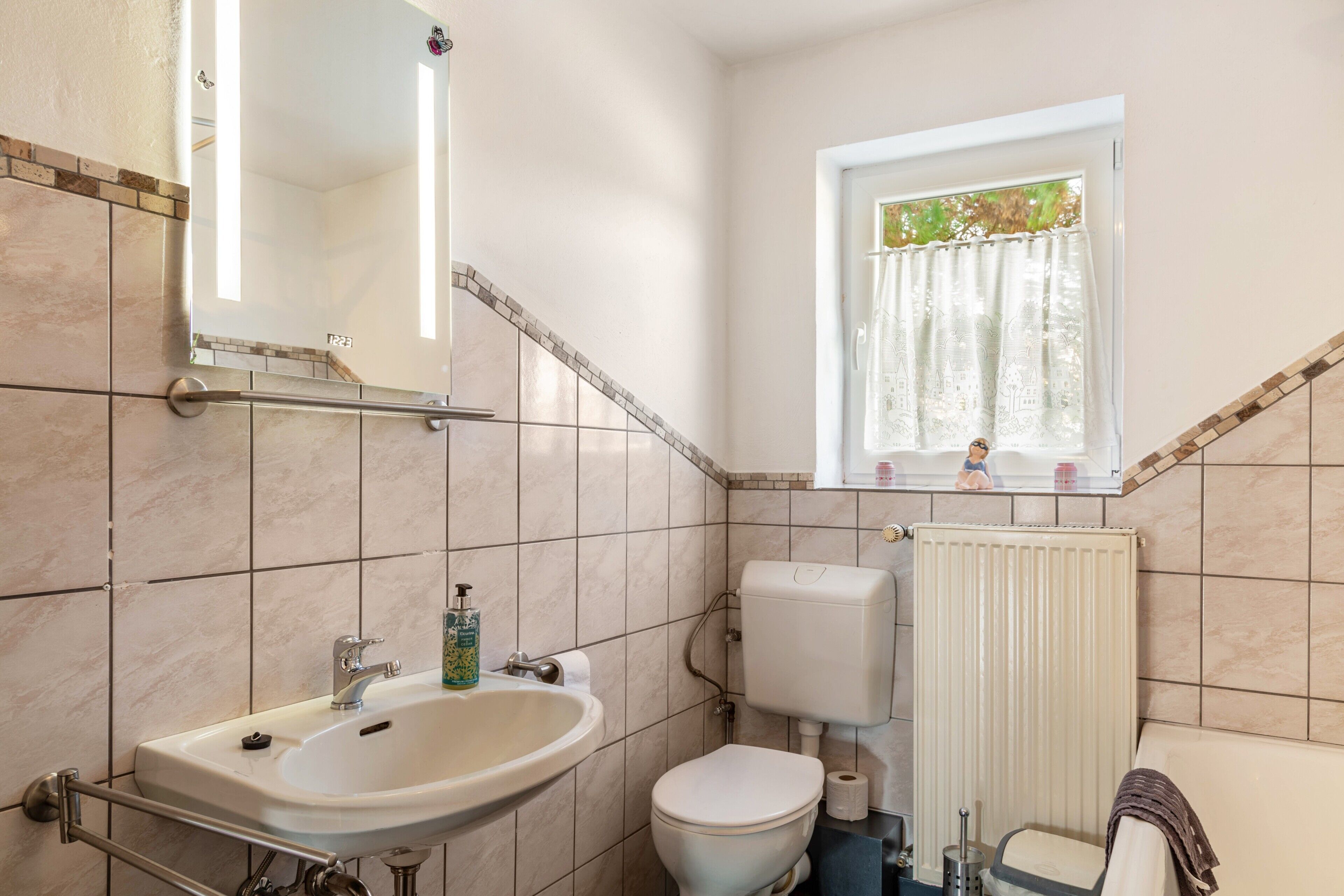 Ein Badezimmer mit Waschbecken, Toilette und Fenster.