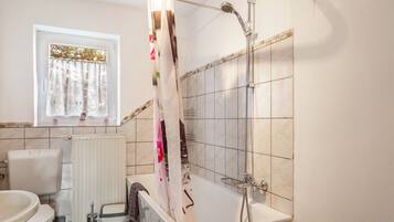 A bathroom with a bathtub, toilet, and sink.