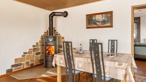 Un comedor con chimenea de piedra, un cuadro en la pared y una mesa con sillas.