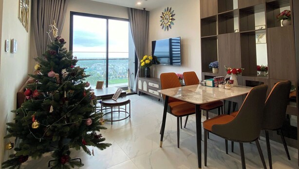 Una sala de estar moderna con comedor, un ventanal grande y un árbol de Navidad.
