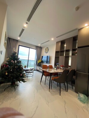 Un comedor moderno con un ventanal grande, un árbol de Navidad y un televisor de pantalla plana.