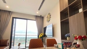 Una sala de estar moderna con un ventanal grande, una mesa de comedor y un televisor.