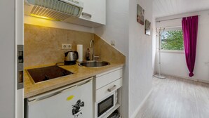 Una cuina compacta amb un rentapeus, fogó i microones.