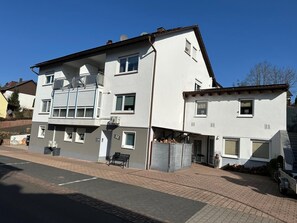 A multi-story residential building with balconies, a garage, and a paved driveway. - Apartment '2' with Wi-Fi (Thaleischweiler-Fröschen)