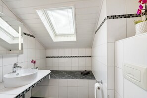 A modern bathroom with a skylight, white tiles, a white sink, and a towel rack. - Apartment '2' with Wi-Fi (Thaleischweiler-Fröschen)
