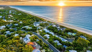 An aerial view of a coastal residential area with houses, roads, and a beach. - Yarrimbah Holiday Retreat  (Peppermint Grove Beach)