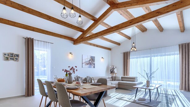 A spacious living area with a wooden ceiling, a dining table set for four, and a sofa. - Jolanda by Interhome (Rovinj/Žminj)