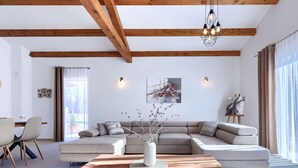 A modern living room with a wooden ceiling, a large L-shaped sofa, a wooden coffee table, and a patterned rug. - Jolanda by Interhome (Rovinj/Žminj)