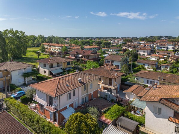 A residential area with multiple two-story houses, featuring red-tiled roofs and a mix of single and double-story buildings.