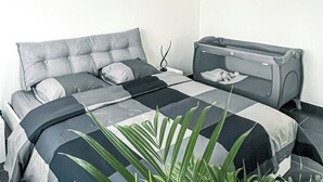 A modern bedroom with a bed, bedside table, and a ceiling fan.
