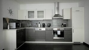 A modern kitchen with stainless steel appliances, a microwave, a coffee maker, and a sink.