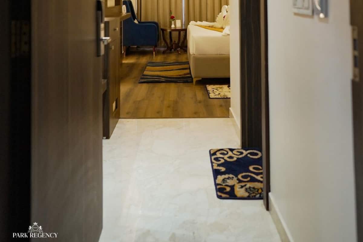 A hotel hallway with a bed, a desk, and a chair.