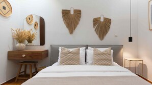 Een slaapkamer met een bed, een dressoir, een spiegel en wanddecoratie.