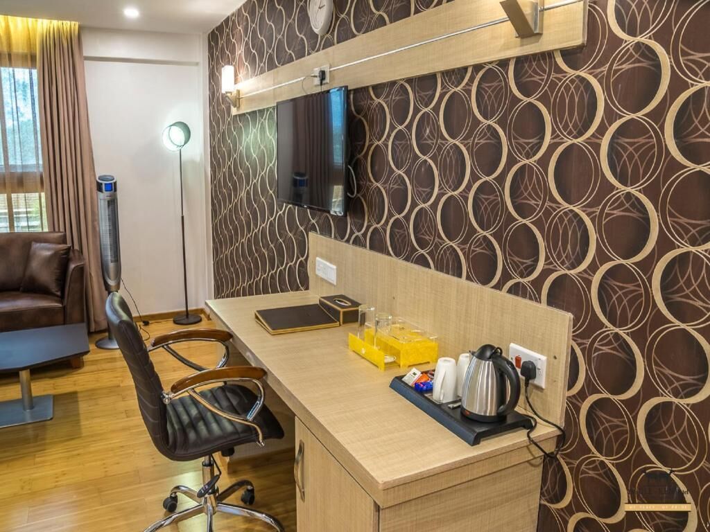 A modern office space with a wooden desk, a leather chair, a clock on the wall, and a patterned wallpaper.