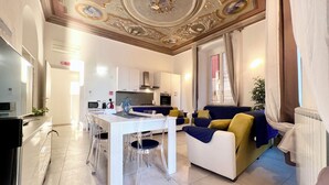 A modern living room with a dining area, a kitchen, and a large window with curtains. - Casa Rosa al Mare, Rapallo (Rapallo)