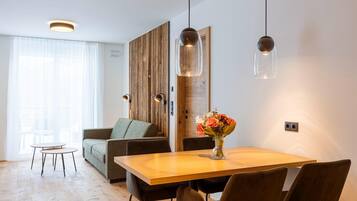 A modern living room with a wooden dining table, a sofa, and a coffee table.