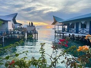 Overwater bungalows with a sunset view, connected by walkways over water. - Amina Holidays (Mabul Island)