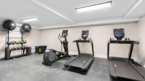 A home gym with treadmills, an elliptical, and a weight rack. - Latitude Suites Tinton Falls Eatontown Bw Premier (Tinton Falls)