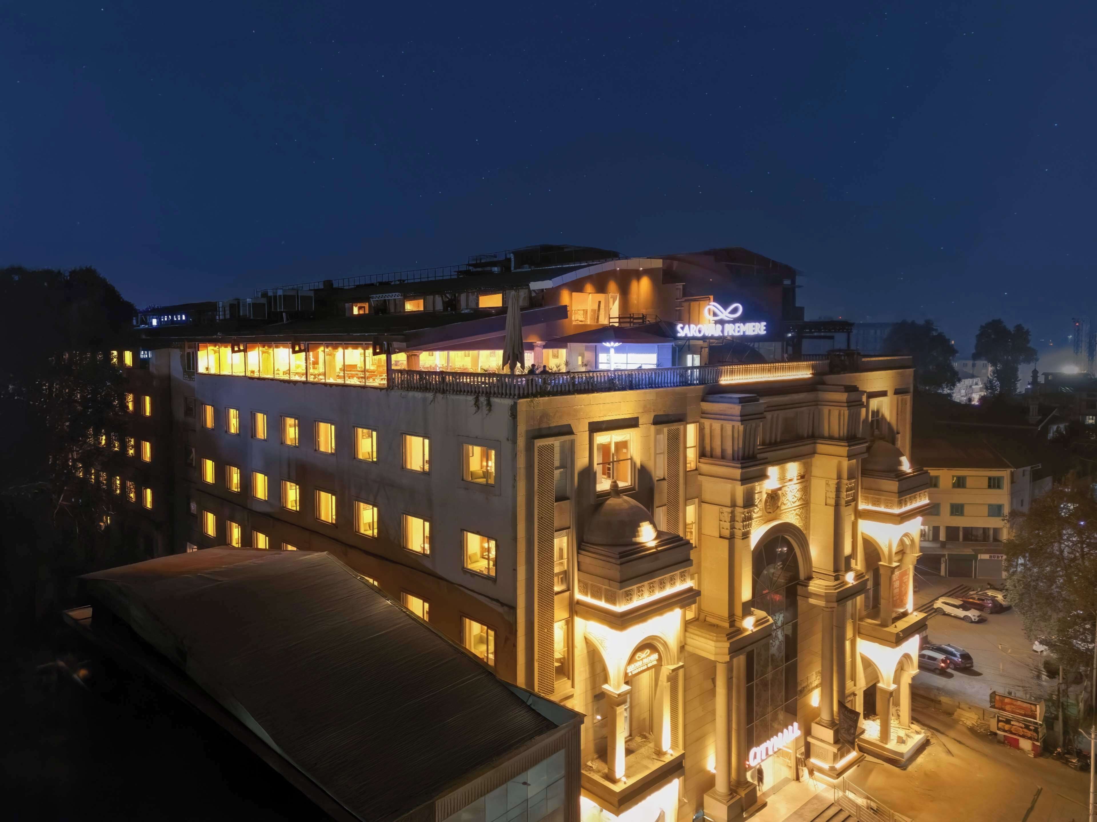 A multi-story hotel with illuminated windows and a prominent entrance with arches.