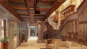A spacious hallway with a wooden staircase, a sofa, and a coffee table. - Sarovar Premiere Srinagar (Srinagar)