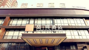 A hotel entrance with a modern facade, large windows, and a sign for James Joyce Coffee.