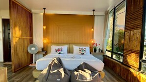 A modern bedroom with a large bed, two bean bags, a standing fan, and a large window with a view. - Bella Lunar Villa (Mae Fa Luang)