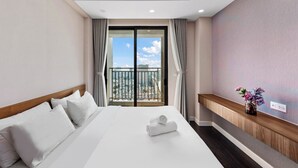 A hotel room with a large bed, a view of the city through a balcony, and a wooden panel accent on the wall. - Amazing CBD Rivergate Apartment & Pool (Ho Chi Minh City)